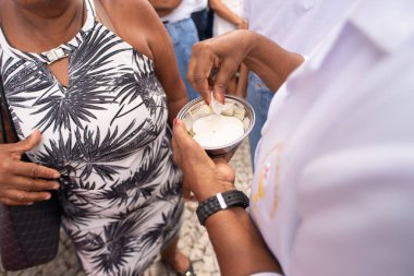 Salvador, Bahia, Brezilya - 26 Aralık 2025: Bahia, Salvador 'daki Sinyor do Bonfim Kilisesi' nde düzenlenen etkinlik sırasında Katolik bir papazın kutsal bir ev sahibini elinde tuttuğu görüldü..