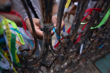 Salvador, Bahia, Brezilya - 26 Aralık 2025: Senyor Bonfim kurdelelerini Salvador, Bahia 'daki kilise kapısına bağlayan ellerin görüntüsü.