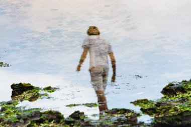 Salvador, Bahia, Brezilya - 2 Şubat 2026: Salvador, Bahia 'da düzenlenen Iemanja festivali sırasında suda yosunlu insan ve kayaların yansımasını gösteren sanatsal perspektif.