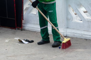 Salvador, Bahia, Brezilya - 7 Şubat 2026: Tatil döneminde Barra kaldırımını süpüren yeşil üniformalı şehir temizleme uzmanı. Salvador, Bahia.