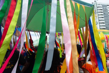 Salvador, Bahia, Brezilya - 14 Şubat 2026: Revizyonerler Salvador, Bahia 'da bir karnaval geçidi sırasında onlardan sarkan renkli şemsiyeler tutuyorlar.