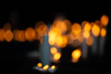 Koyu renk bir mum tutacağında yakılan birkaç beyaz mum, dini bir ortamda istekleri ve minnettarlığı sembolize ediyor..