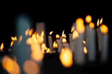 Koyu renk bir mum tutacağında yakılan birkaç beyaz mum, dini bir ortamda istekleri ve minnettarlığı sembolize ediyor..