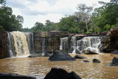 Uçsuz bucaksız bir çıkıntının üzerinde geniş bir şelale..