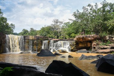 Uçsuz bucaksız bir çıkıntının üzerinde geniş bir şelale..