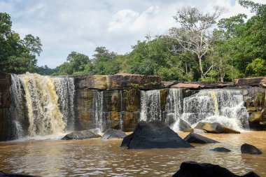 Uçsuz bucaksız bir çıkıntının üzerinde geniş bir şelale..