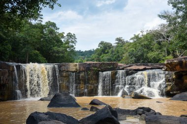 Uçsuz bucaksız bir çıkıntının üzerinde geniş bir şelale..