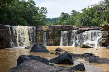 Uçsuz bucaksız bir çıkıntının üzerinde geniş bir şelale..
