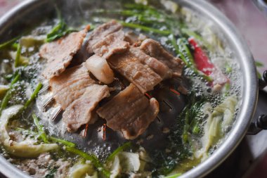 Tayland usulü sıcak bir tencerede ızgara domuz eti dilimleri.).