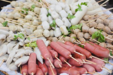 Çeşitli sosisler ve balık köfteleri pişirmeye hazır..