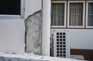 Çatlamış beton duvar ve pencerenin altındaki boyayı soymak..