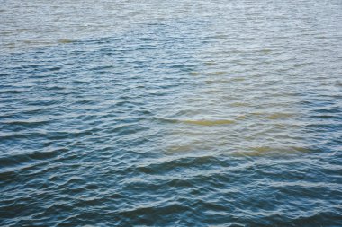 Küçük dalgalar ve dalgalarla mavi-gri suyun yakın görüntüsü.