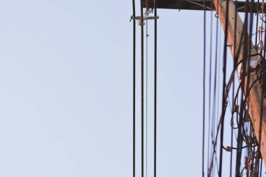 Aydınlık bir gökyüzüne karşı dikey güç hatlarının yakın çekimi.