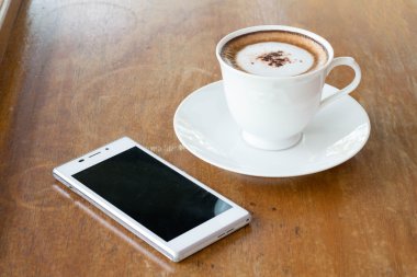 fincan kahve ve ahşap masa akıllı telefon