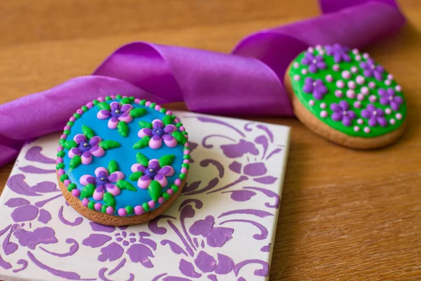 Gingerbread with flowers and purple ribbon — Stock Photo, Image