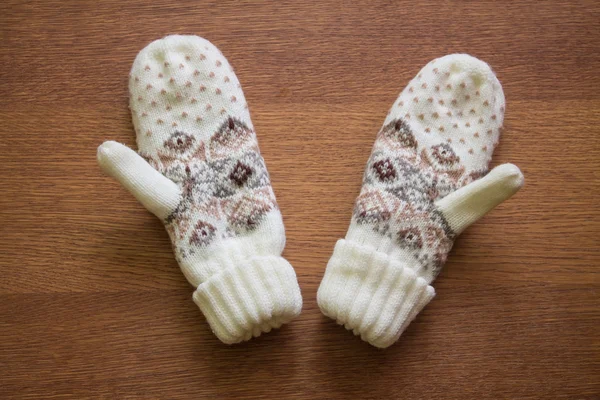 Knitted mittens with ornament on wood background — Stock Photo, Image