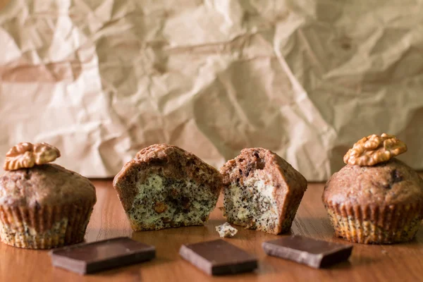 Ahşap masa üzerinde ısırıldı bicolor muffins. — Stok fotoğraf