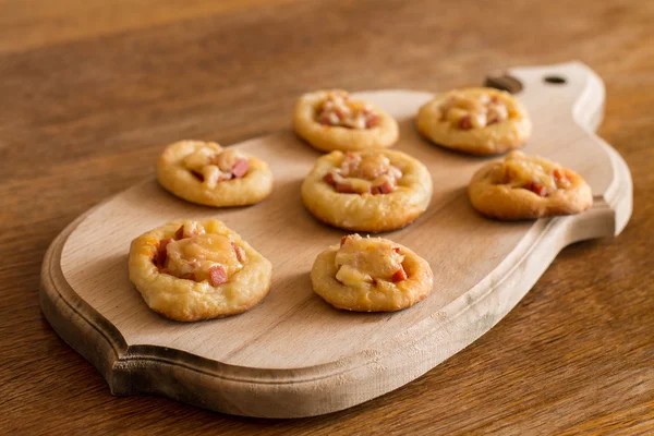 Mini pizzas na placa de corte — Fotografia de Stock