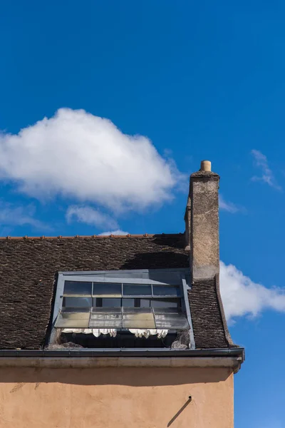 çatıdaki baca ve bulutlu eski pencere çerçevesi