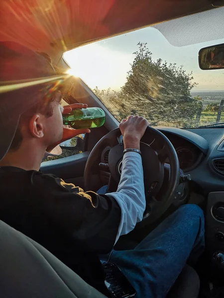 Araba kullanırken bira içen genç insanlar. Yol güvenliği: Alkollü araç kullanma 