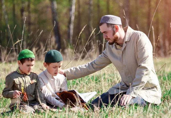 Vater bringt den Kindern das Lesen des Qran bei — Stockfoto