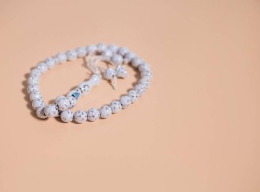 Bej arka planda beyaz tespih..