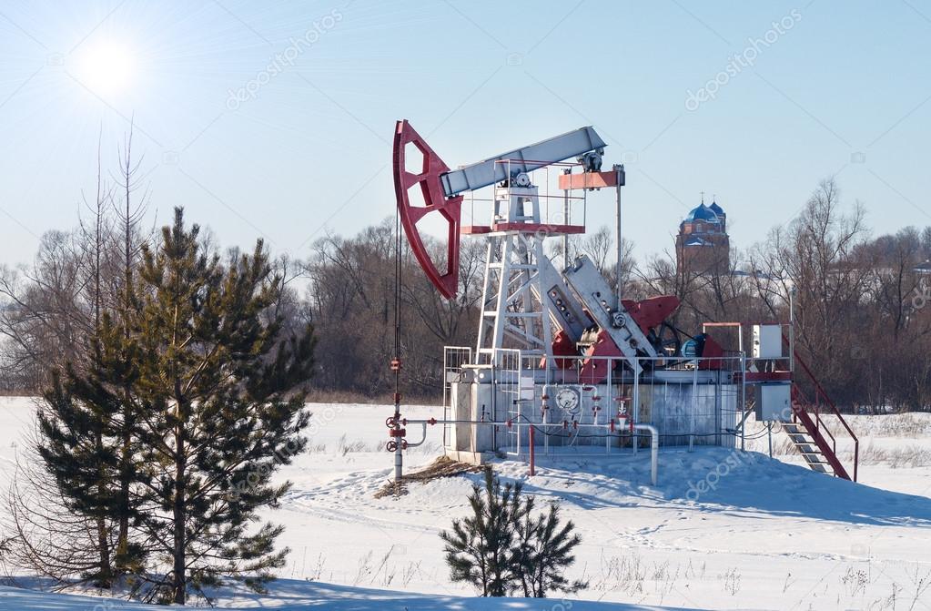 oil pump works on winter forest background
