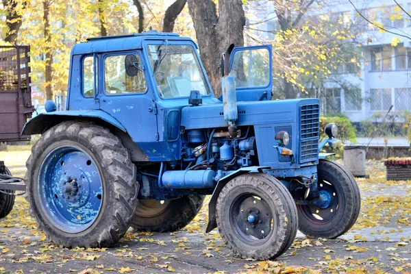 Синій трактор в осінньому парку — стокове фото