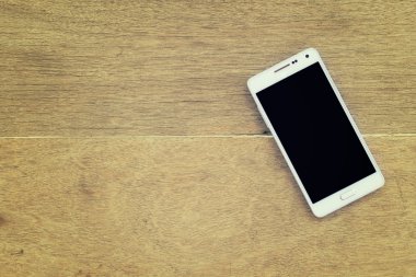 ahşap arka plan üstünde hareket eden telefon.