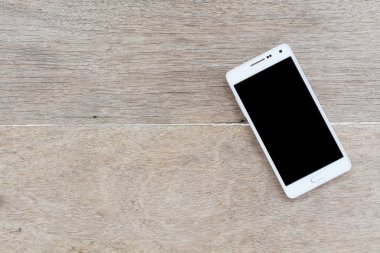 ahşap arka plan üstünde hareket eden telefon.