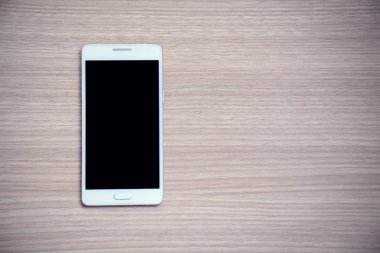 ahşap arka plan üstünde hareket eden telefon.