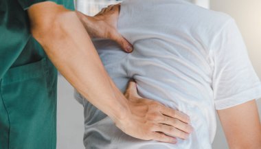 Omurga ağrıları konusunda hastaya fizyoterapist danışmanlık yapıyor. Fizik tedavi kavramı.