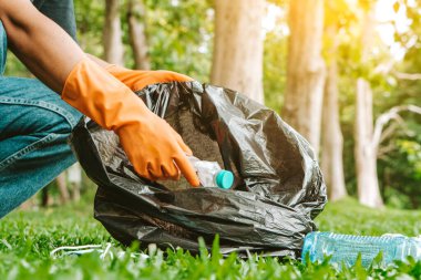 Çöpleri toplayan gönüllü bir adam. Çöp şişeleri toplandı. Plastik ve gıda atığı konsepti. Dünya gezegenini temizle, çöpleri topla, çevreyi kurtar, dünyayı kurtar..