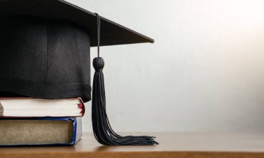 Tahta üzerinde diploma ve kitap olan havan mermisi tahtası. mezuniyet kavramı.