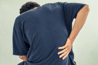 Evdeki sandalyede otururken acıdan muzdarip bir adamın yakın çekimi, vücut-kas problemi, sağlık ve tıp konsepti