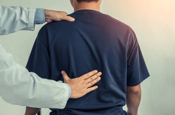 Doktor ya da fizyoterapist hastanın sırt problemlerine danışmanlık yapıyor. Fizik tedavi kavramı..