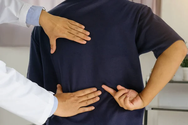 Doktor ya da fizyoterapist hastanın sırt problemlerine danışmanlık yapıyor. Fizik tedavi kavramı..