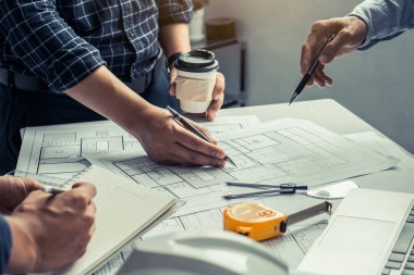 Mimarlık ve mühendislik toplantıları ofiste tartışılacak bir çizime işaret ediyor. Mühendislik araçları ve inşaat konsepti.