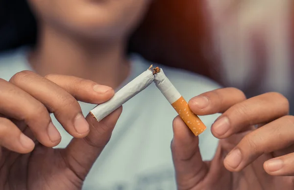 Sigara. Dünya Tütünsüz Günü Konsepti. Sigara içmeyi bırak. Kırık sigarayı elinde tutan kadın..