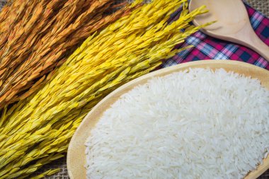 Pirinç çuval veya ahşap masa arka plan üzerinde ahşap kase