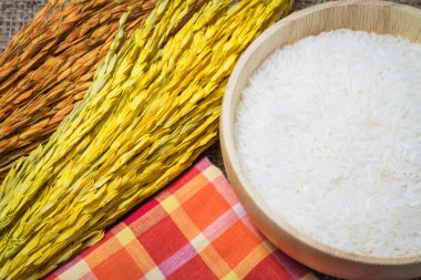 Pirinç çuval veya ahşap masa arka plan üzerinde ahşap kase