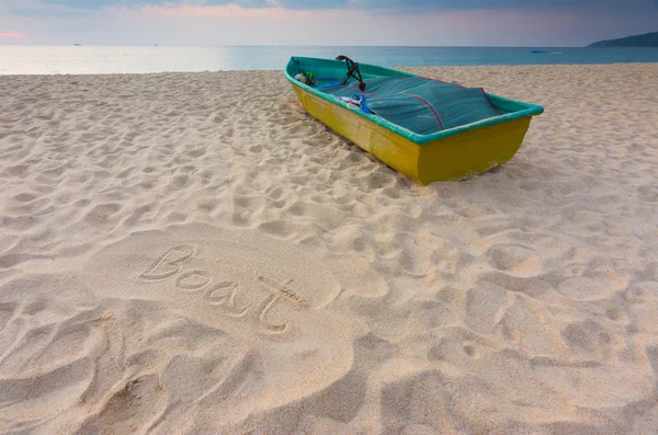 Pequeno barco na praia com placa de areia para escrever — Fotografia de Stock