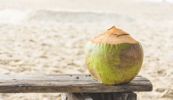 Água de coco fresca na velha cadeira de madeira na praia em Phuket  , — Fotografia de Stock