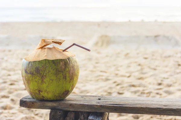 Água de coco fresca na velha cadeira de madeira na praia em Phuket  , — Fotografia de Stock