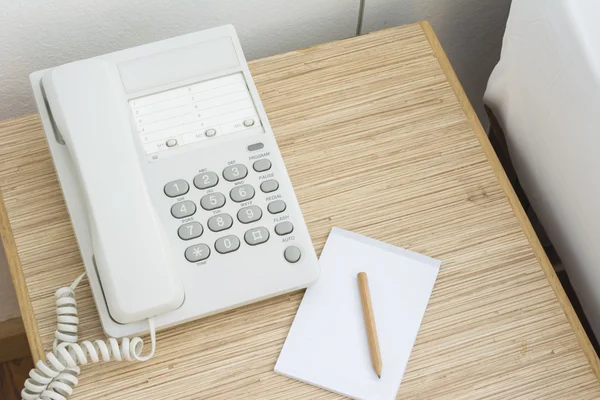 Telefonda bir kağıt defter ve kalem ile tablo. İçinde 