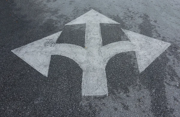Semnele săgeată în trei direcții pe drum — Fotografie, imagine de stoc