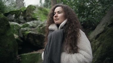 Kıvırcık saçlı kız derin bir nefes alır ya da temiz havada meditasyon yapar. Yeşil orman ve temiz çevre. Şehirden uzak temiz hava. Sağlıklı nefes