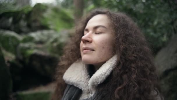 巻き毛の少女は深呼吸をするか 新鮮な空気中で瞑想します 緑の森ときれいな環境 街から空気をきれいにしなさい 健康な呼吸 — ストック動画