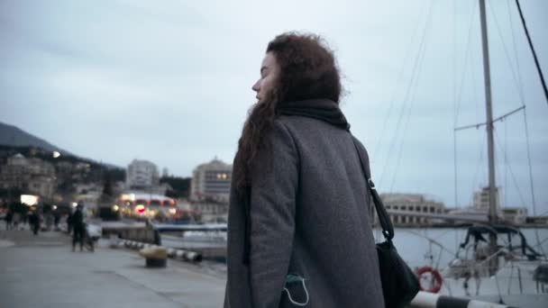 Kobieta Długim Płaszczu Spaceruje Wzdłuż Nabrzeża Światła Sklepu Migają Oddali — Wideo stockowe