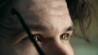 Yavaş çekim yakın kare. Adam eski ve kirli optik gözlüklerini plastik çerçevelerle çıkarıyor. Adamın biri gözünün üstüne lens takıyor. Görme düzeltmesinin yeni veya alternatif yolları 